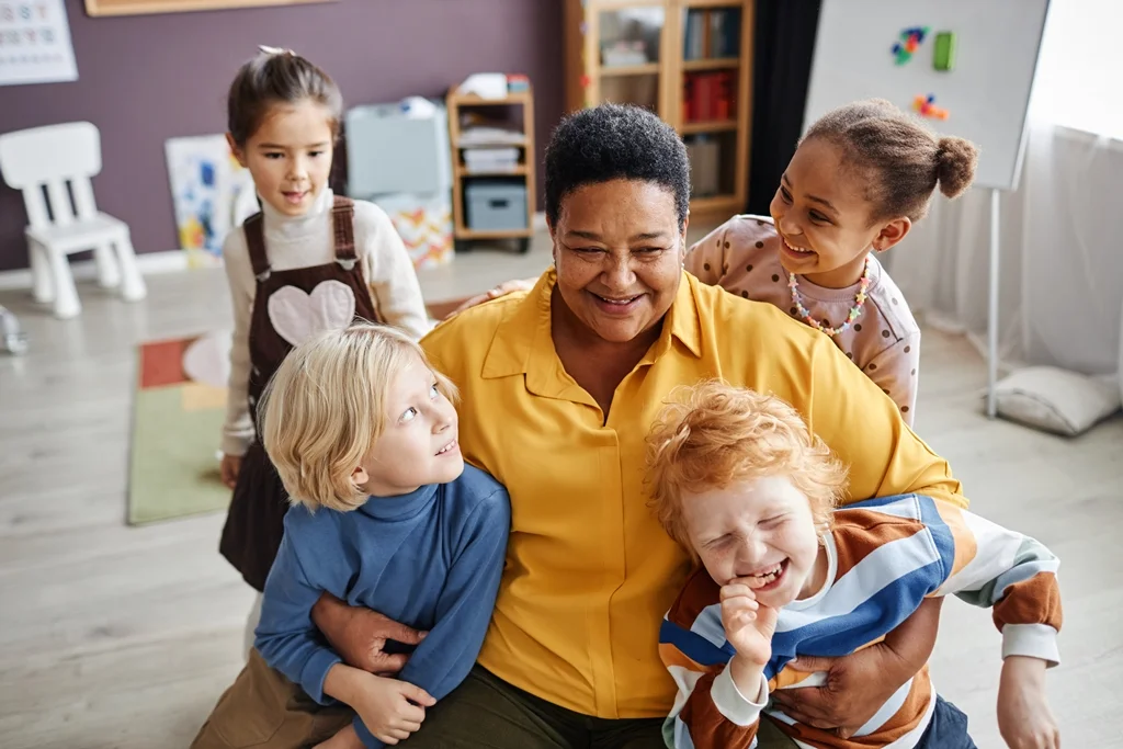diverse children with smiling teacher classroom